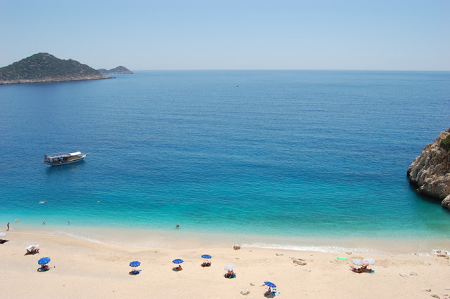 Aerial view of Kaputas Beach with parasols and sun loungers on beach and pristine turquoise sea